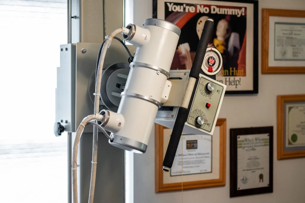 Cervical traction device mounted on wall bracket with control panel in chiropractor office