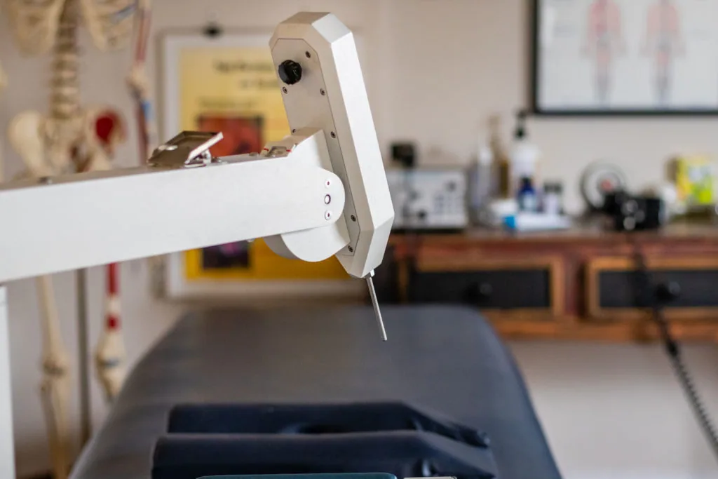 White robotic device with camera mounted on articulated arm in medical office setting